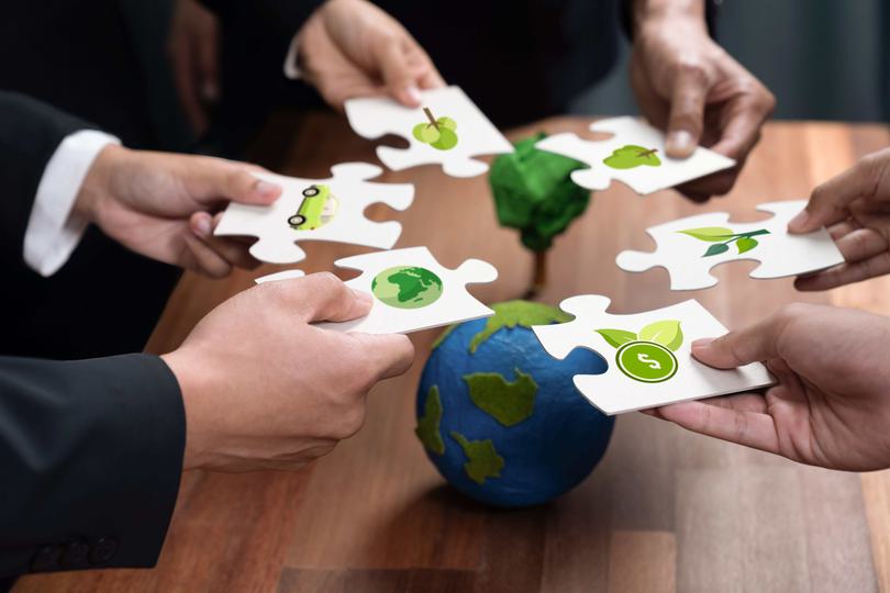 Hands holding jigsaw pieces with environmental images